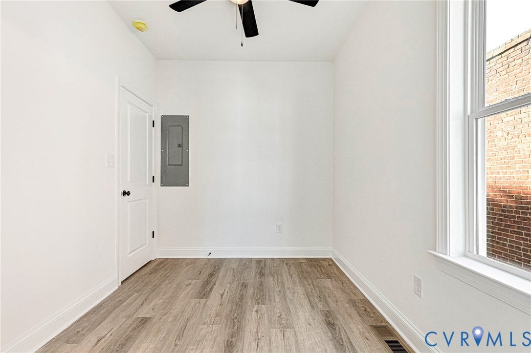 Wood-finish flooring, white walls, and a ceiling fan with light fixture