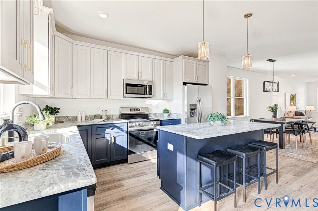 Two-tone cabinetry with stainless steel appliances, a center island, and wood-finish flooring