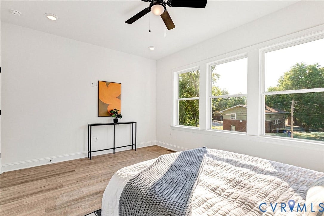 Recessed lighting, ceiling fan, three expansive windows, and wood-finish flooring