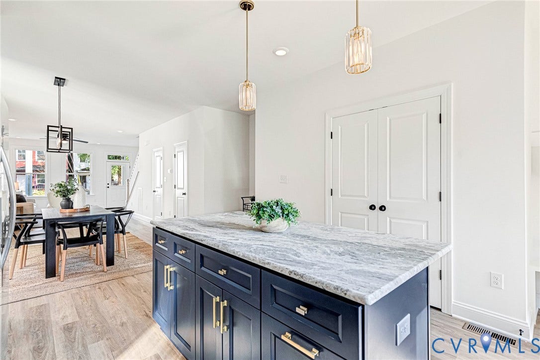 Kitchen island with a light-colored countertop and dark blue cabinetry