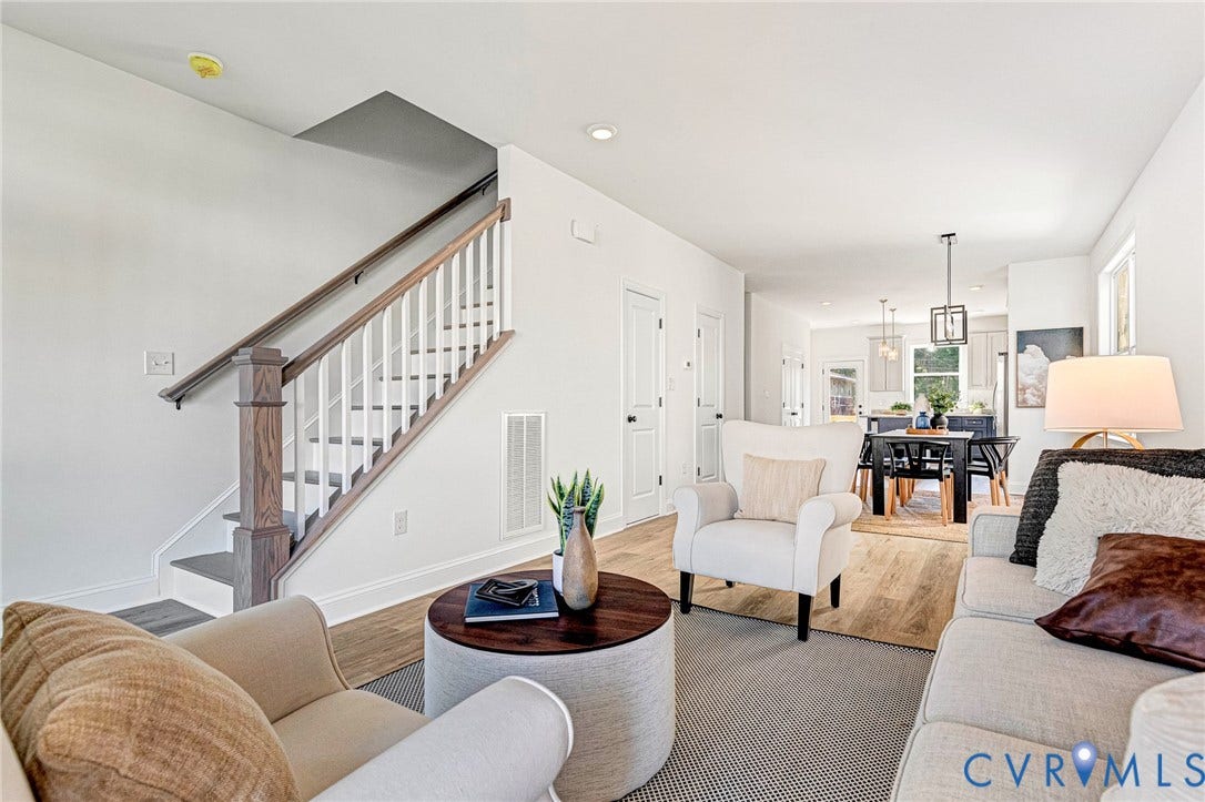 Staircase with wood newel post and handrail, white balusters, and gray treads