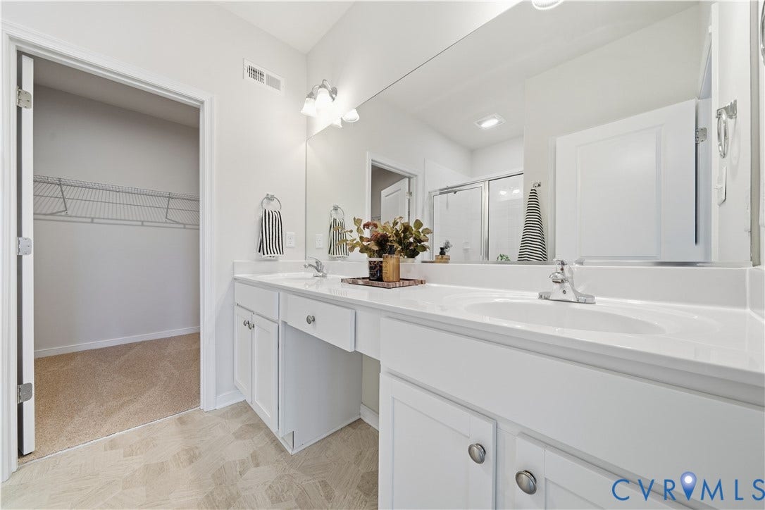 Primary bathroom with dual sinks and vanity area