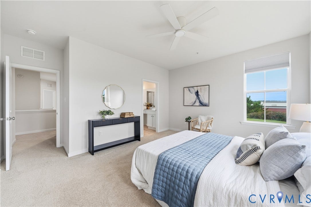 Primary Bedroom with windows that overlook the courtyard and the open land to the side.
