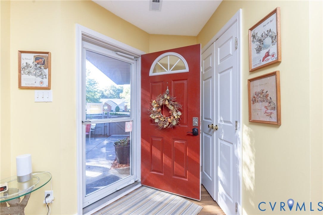 Red paneled entry door with an arched transom window