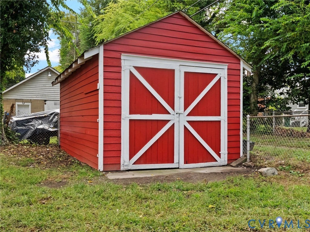 Red exterior shed with white trim and double barn doors