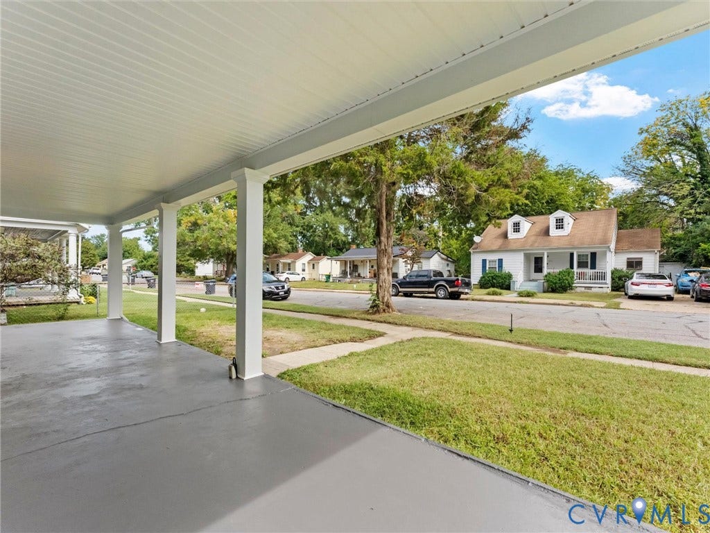 Covered concrete porch with square columns and a slatted ceiling