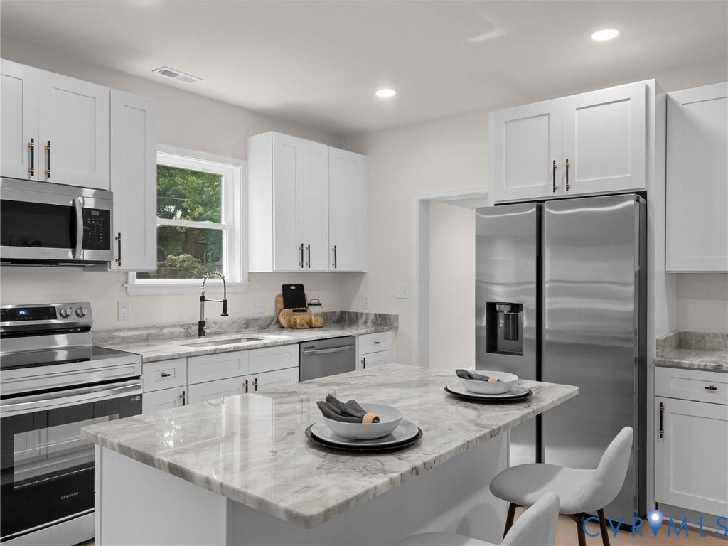 Kitchen featuring white cabinetry, stainless steel appliances, recessed lighting, a kitchen island with a stone countertop, and stone countertops