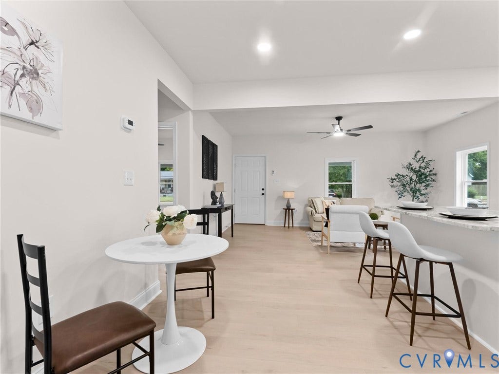 Open-concept living area with wood-finish flooring, recessed lighting, and a ceiling fan