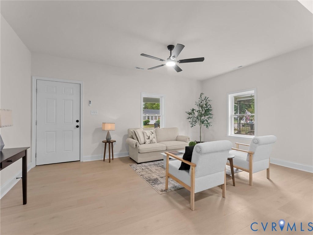Light wood-finish flooring, white paneled door, multiple windows, ceiling fan with integrated lighting