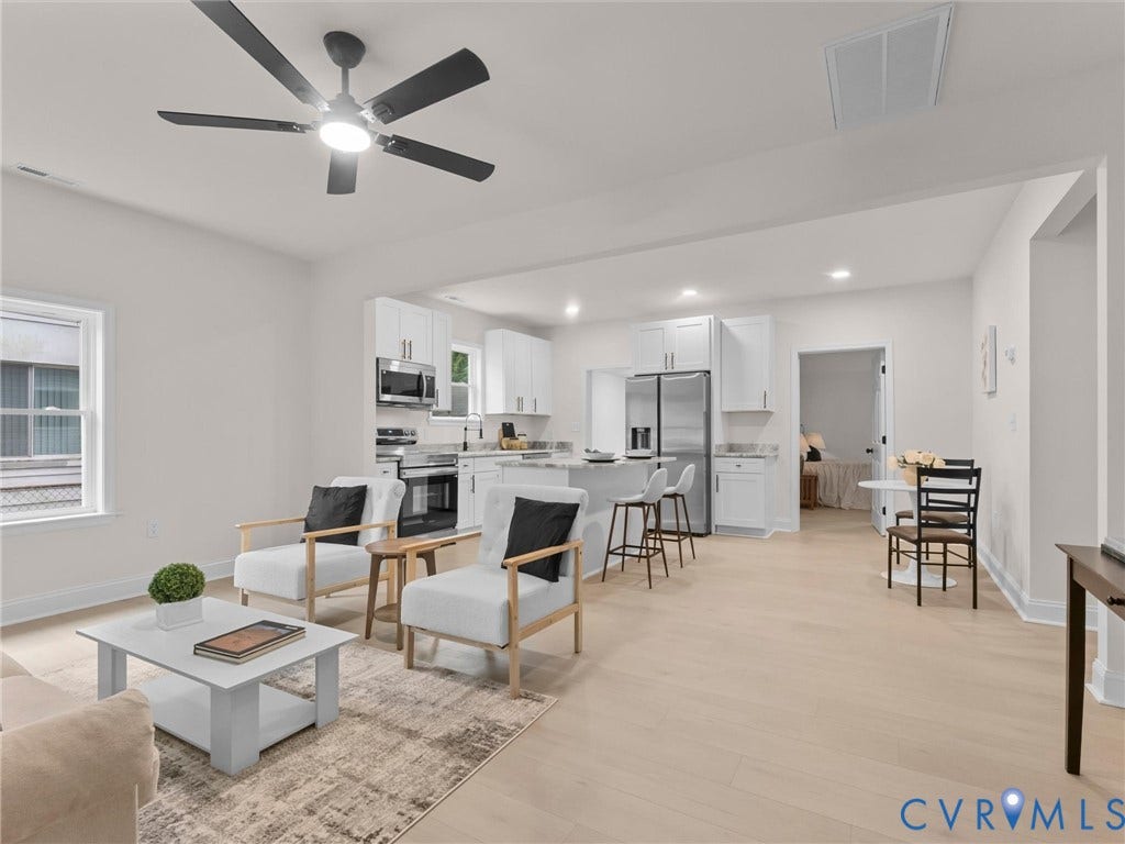 Open concept living space featuring wood-finish flooring, a modern ceiling fan, and white walls