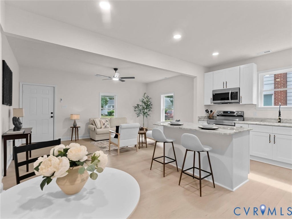 Open concept living area with wood-finish flooring, recessed lighting, and a modern ceiling fan