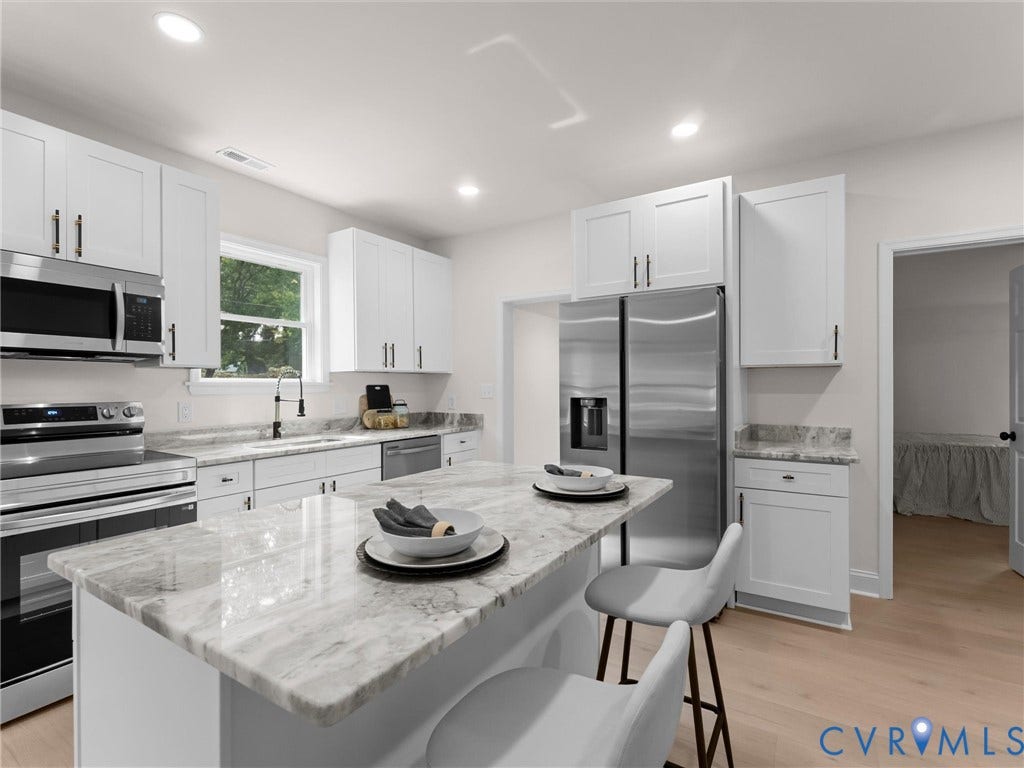 Kitchen featuring white cabinetry, stainless steel appliances, recessed lighting, and light-toned wood-finish flooring