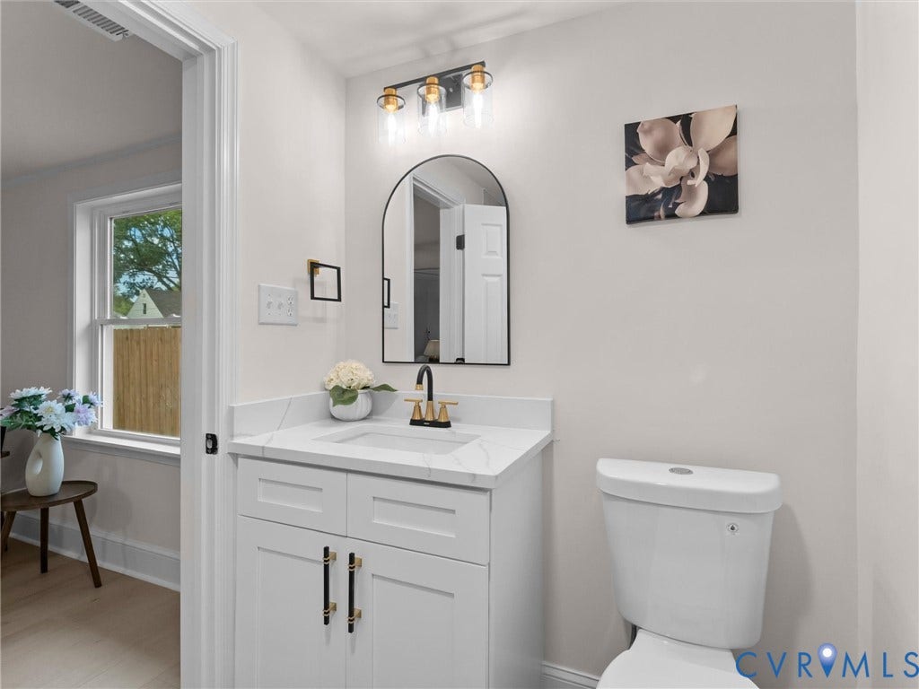 White vanity with a stone-finish countertop and integrated sink
