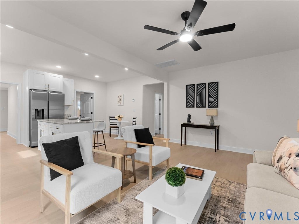 Open-concept living space with light wood-finish flooring, recessed lighting, and a modern ceiling fan