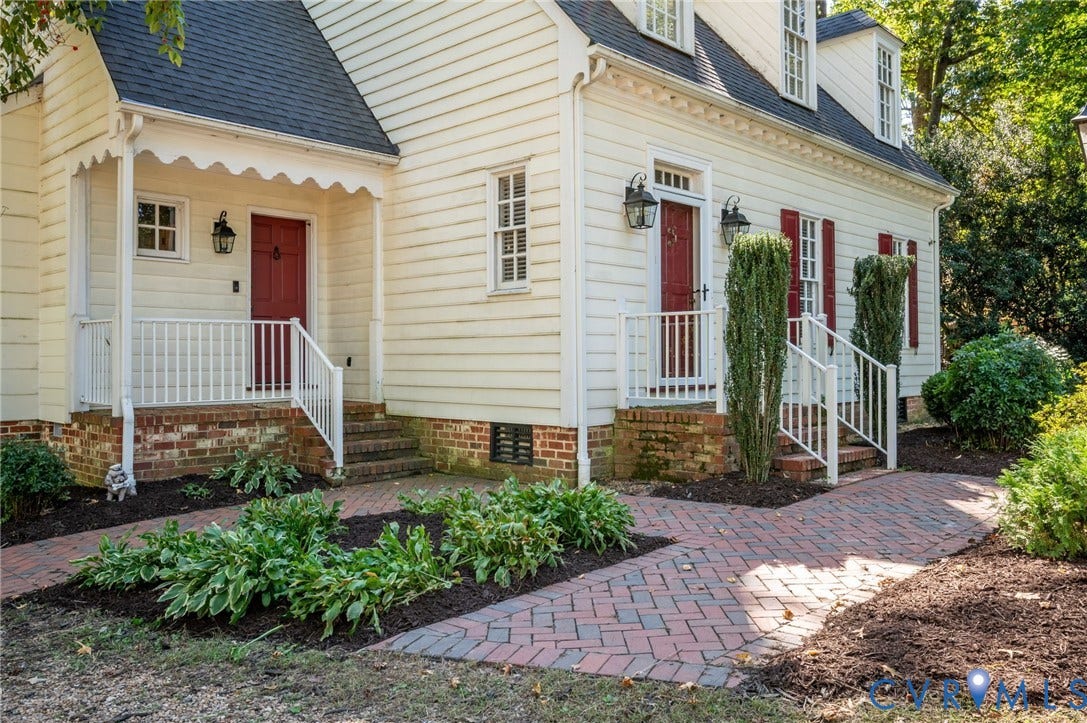 10303 Silverbrook Drive, Henrico, VA 23233 White siding exterior with brick foundation, red doors, white railings, and brick-patterned walkway