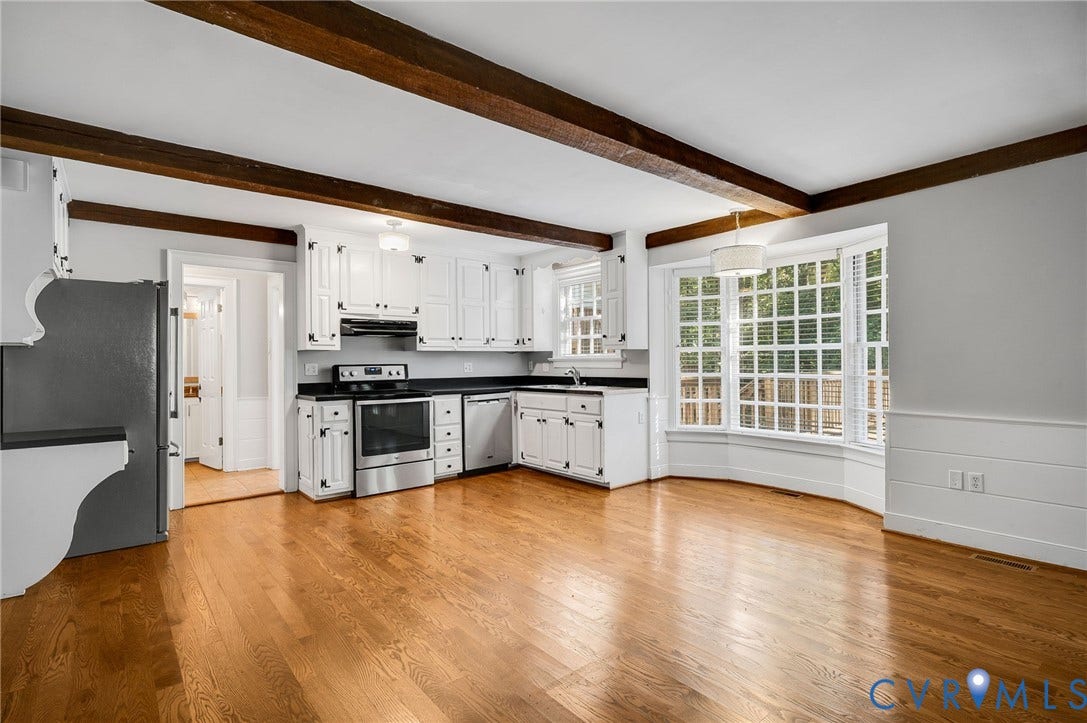 10303 Silverbrook Drive, Henrico, VA 23233 Exposed wood ceiling beams, white cabinetry, dark countertops, stainless steel appliances, and a large bay window