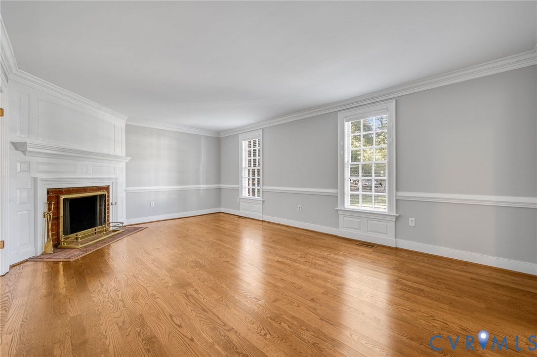 10303 Silverbrook Drive, Henrico, VA 23233 Hardwood flooring, brick-surround fireplace with a white mantel, white crown molding, white chair rail molding, and multiple windows