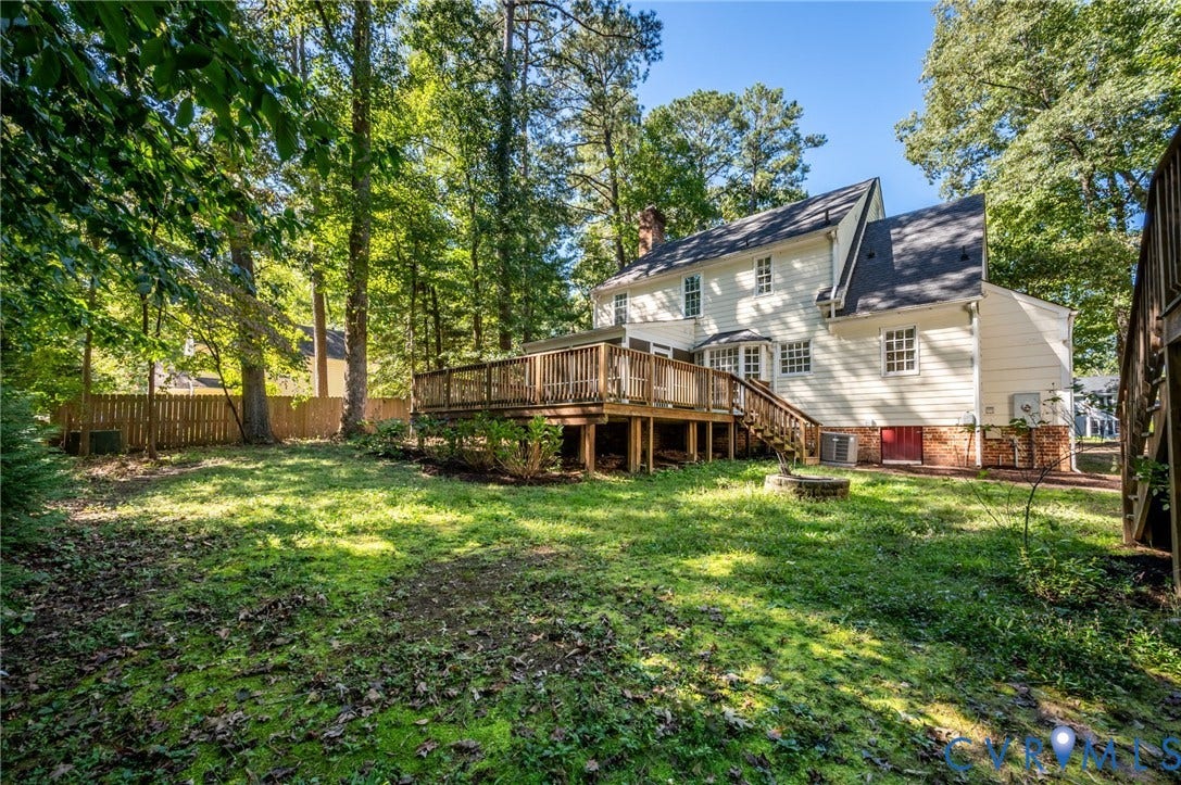 10303 Silverbrook Drive, Henrico, VA 23233 Expansive rear yard featuring a multi-level wood deck, white siding, and a brick foundation