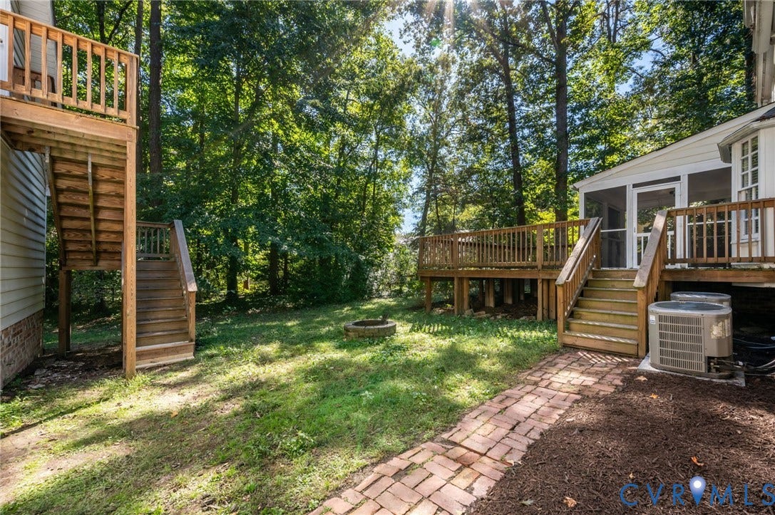 10303 Silverbrook Drive, Henrico, VA 23233 Expansive backyard featuring a brick paver pathway, a fire pit, and a screened porch