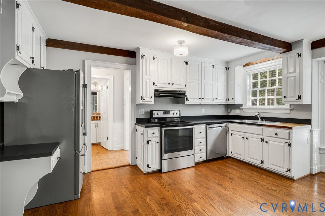 10303 Silverbrook Drive, Henrico, VA 23233 Wood-finish flooring, white cabinetry with dark hardware, stainless steel appliances, dark countertops, and exposed ceiling beams