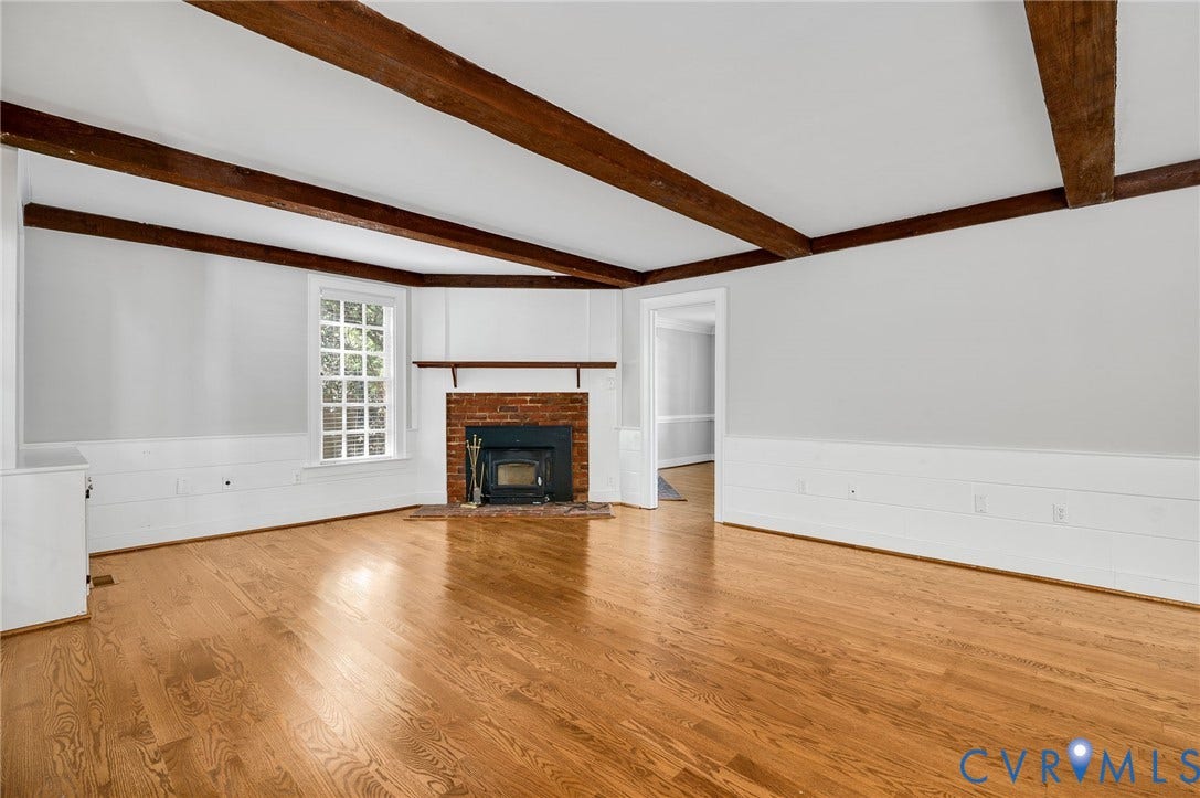 10303 Silverbrook Drive, Henrico, VA 23233 Hardwood flooring, exposed ceiling beams, brick fireplace with wood-burning stove, grid-pattern window, and wainscoting