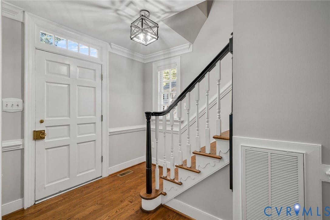 10303 Silverbrook Drive, Henrico, VA 23233 Entryway featuring a paneled door with transom window, wood-finish flooring, a staircase with wood treads and white balusters, and a geometric flush-mount light fixture