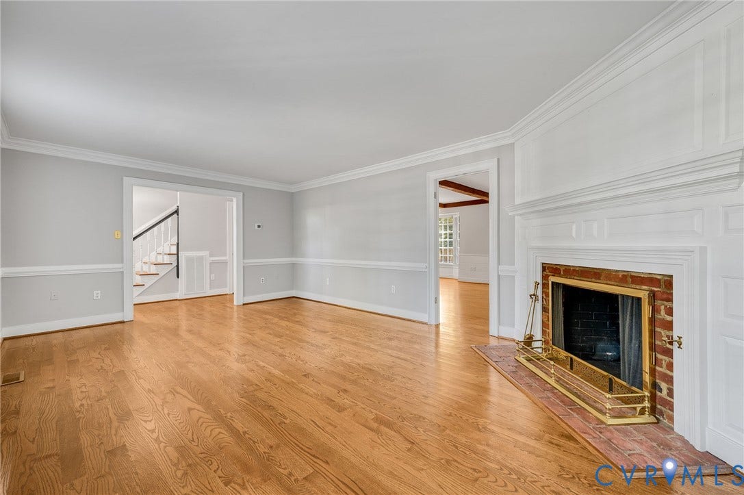10303 Silverbrook Drive, Henrico, VA 23233 Hardwood flooring, brick fireplace surround, substantial white mantel, crown molding, and chair rail detailing