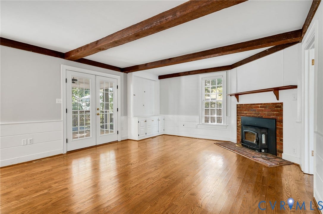 10303 Silverbrook Drive, Henrico, VA 23233 Hardwood flooring, exposed wood ceiling beams, white shiplap wainscoting, brick fireplace with wood-burning insert, and French doors