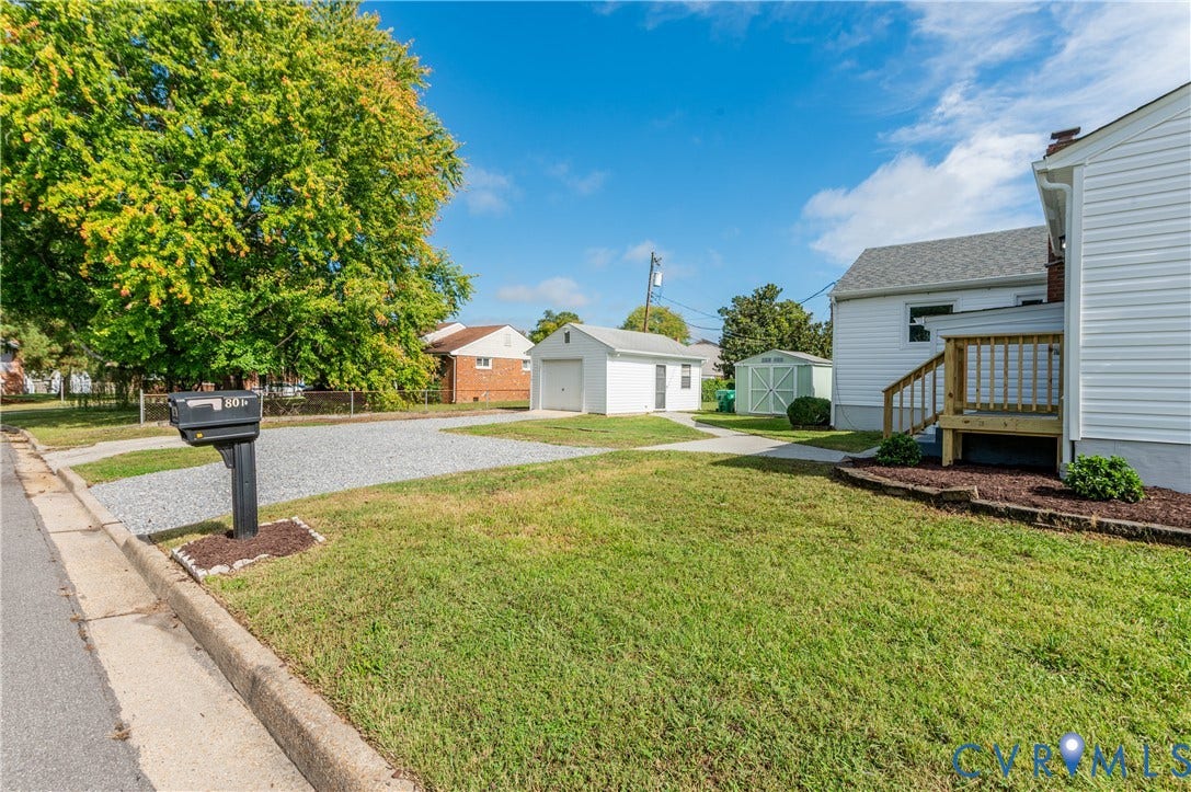 8010 Callison Drive, Glen Allen, VA 23060 Expansive front yard with a gravel parking area, mature trees, and a detached garage