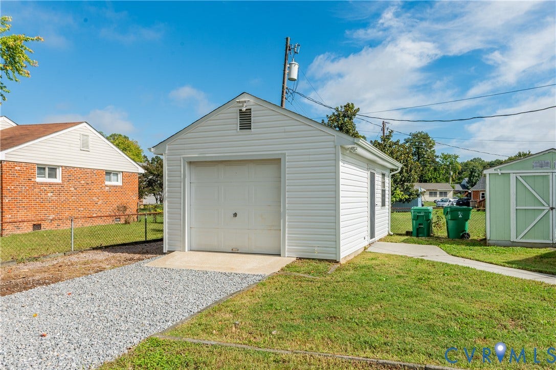 8010 Callison Drive, Glen Allen, VA 23060 Detached garage with white siding, a white garage door, and an adjacent gravel driveway