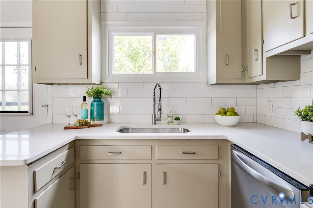 8010 Callison Drive, Glen Allen, VA 23060 U-shaped countertop with an undermount sink, stainless steel faucet, subway tile backsplash, and light-toned cabinetry