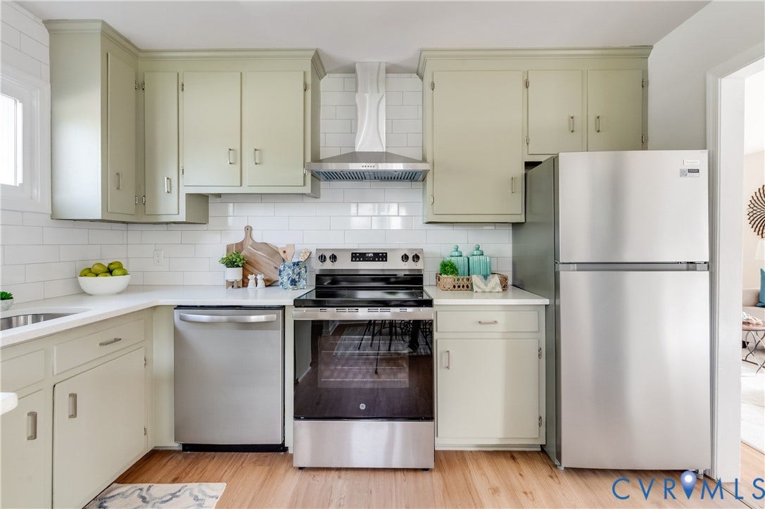 8010 Callison Drive, Glen Allen, VA 23060 U-shaped kitchen with light-toned cabinetry, stainless steel appliances, white subway tile backsplash, and wood-finish flooring