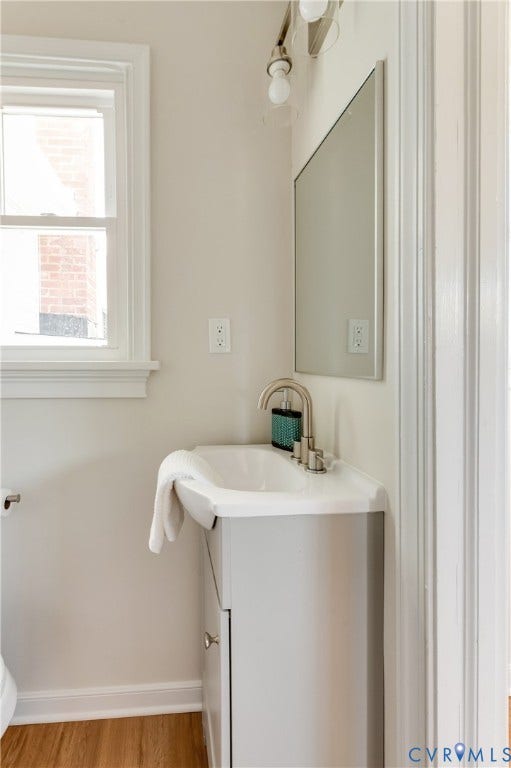 8010 Callison Drive, Glen Allen, VA 23060 White pedestal sink with brushed nickel faucet, light gray vanity, and wood-finish flooring