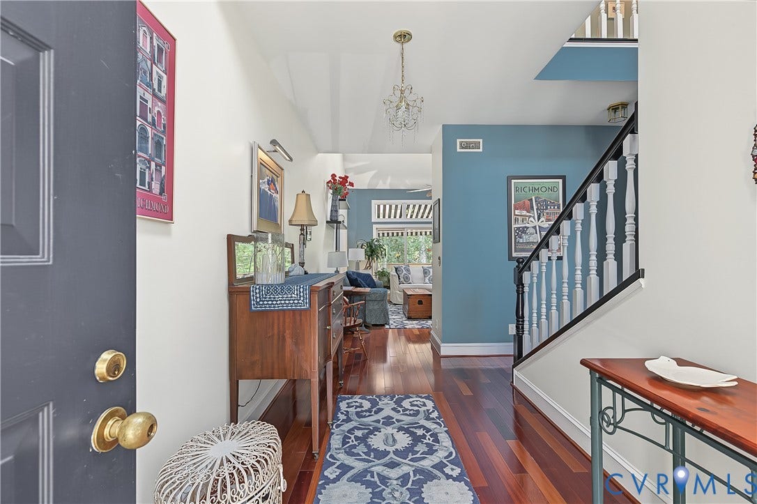 3131 Stony Point Road, #B, Richmond, VA 23235 Hardwood flooring throughout the entry, staircase with white balusters, and a decorative chandelier