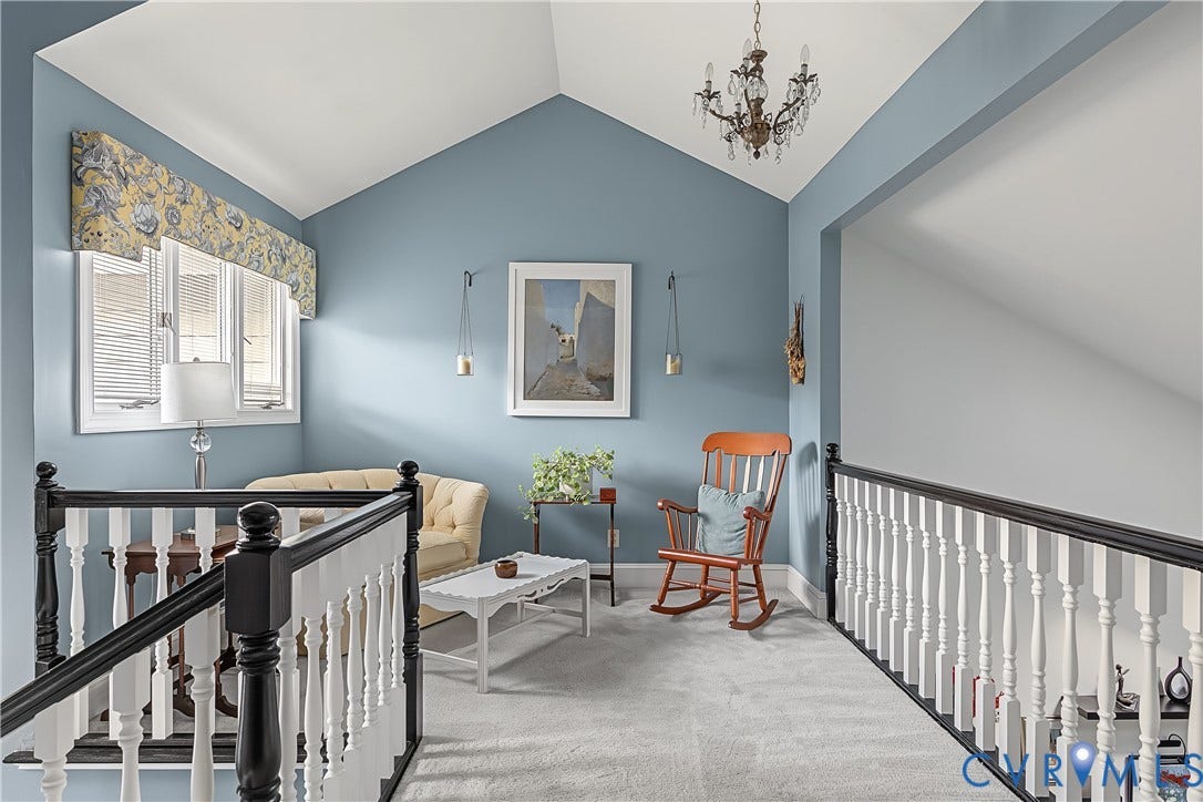 3131 Stony Point Road, #B, Richmond, VA 23235 Sloped ceiling with an ornate chandelier, window with white blinds, and a staircase featuring a white and black banister