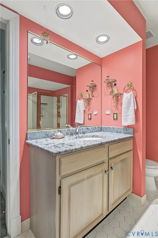 3131 Stony Point Road, #B, Richmond, VA 23235 Recessed lighting illuminates the vanity featuring a light-toned wood cabinet, a light-colored countertop with an integrated sink, and an expansive wall mirror