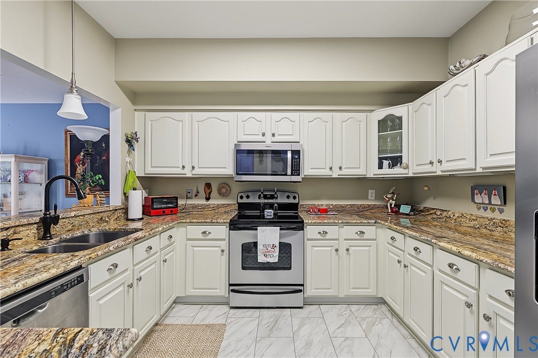 3131 Stony Point Road, #B, Richmond, VA 23235 U-shaped kitchen featuring white cabinetry, stainless steel appliances, speckled countertops, and tile flooring