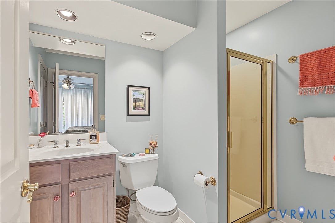 3131 Stony Point Road, #B, Richmond, VA 23235 Recessed lighting illuminating a single vanity with a white countertop, a toilet, and a stand-up shower with a gold-toned frame