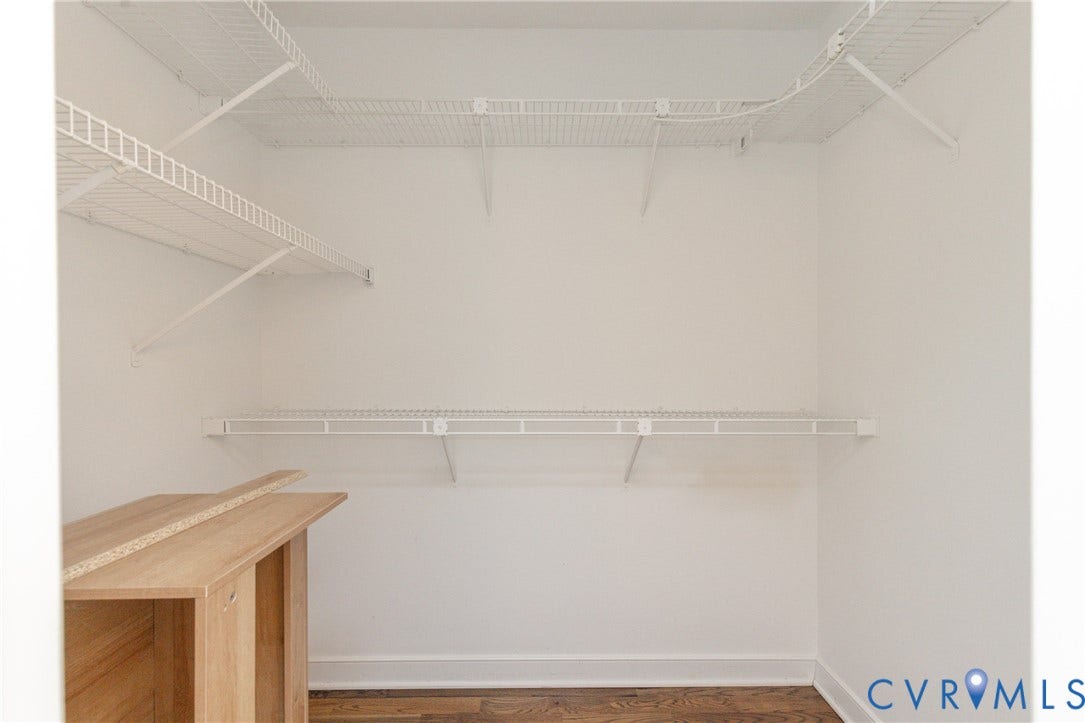 White wire shelving system, light wood-finish flooring, white walls, and white trim