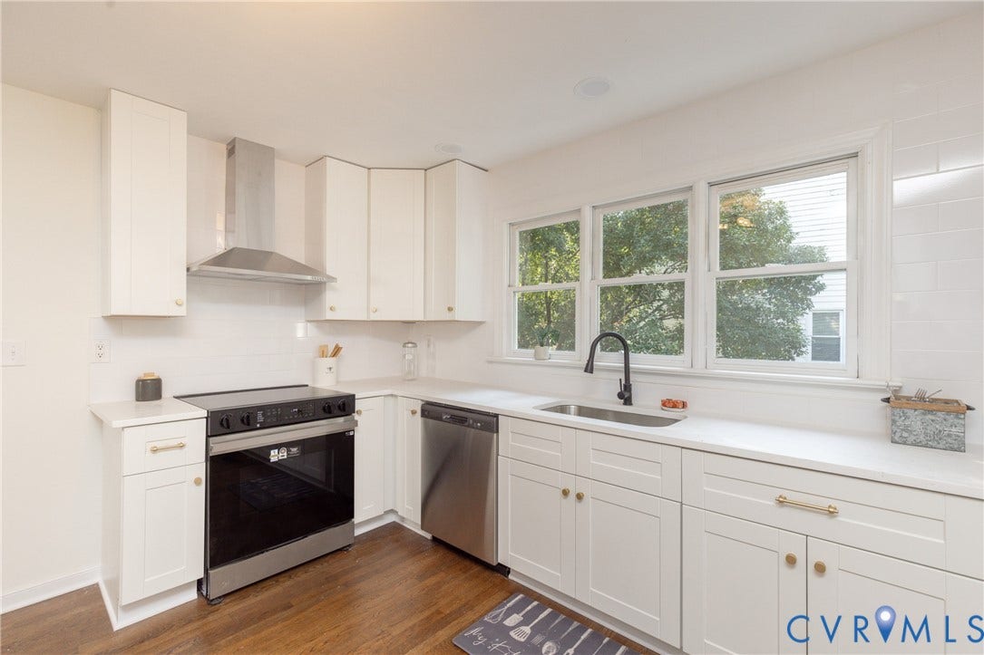 Kitchen featuring white shaker-style cabinetry, stainless steel appliances, a stainless steel sink with a matte black faucet, white countertops, and a white subway tile backsplash