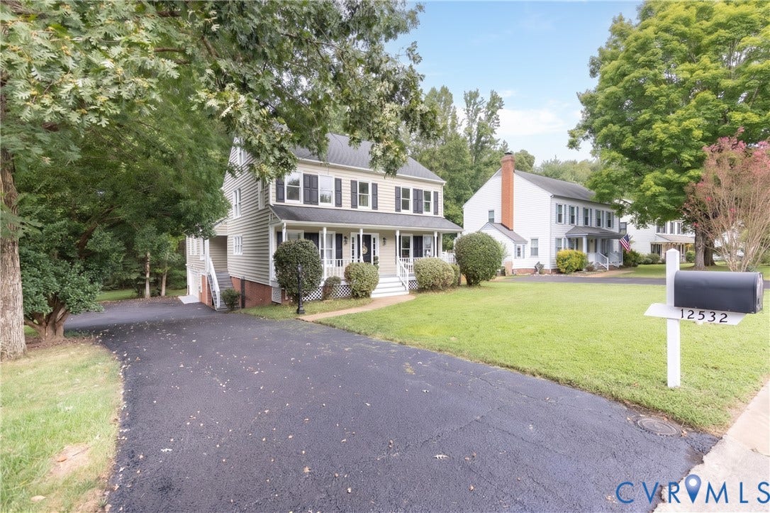 Two-story residence with a covered porch and mature landscaping