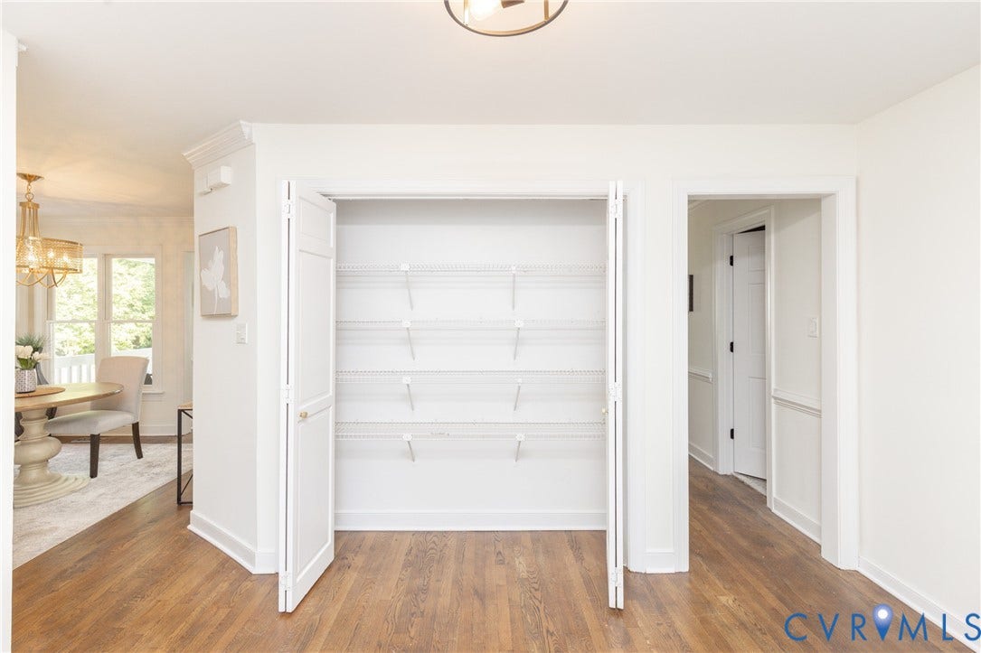 Wide plank wood-finish flooring, white walls, bi-fold closet doors, wire shelving, and recessed lighting