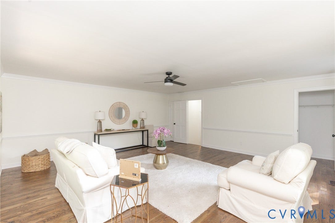 Spacious living area featuring wood-finish flooring, crown molding, a ceiling fan, and white walls