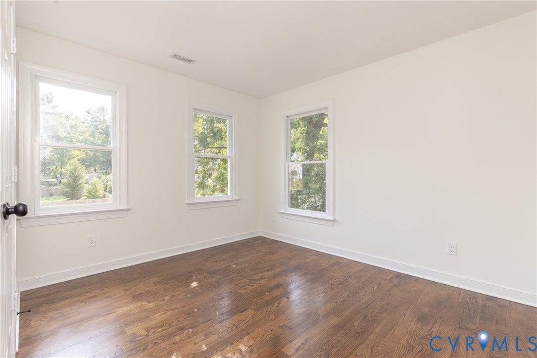 Wood-finish flooring, white walls, and two double-hung windows