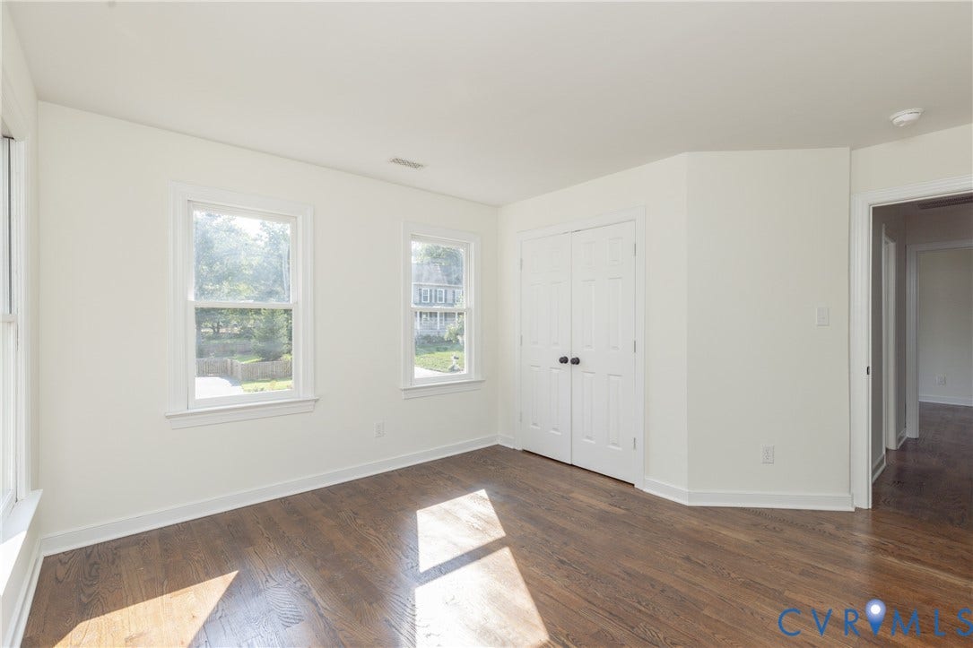 Wood-finish flooring throughout, white walls, and bright white trim