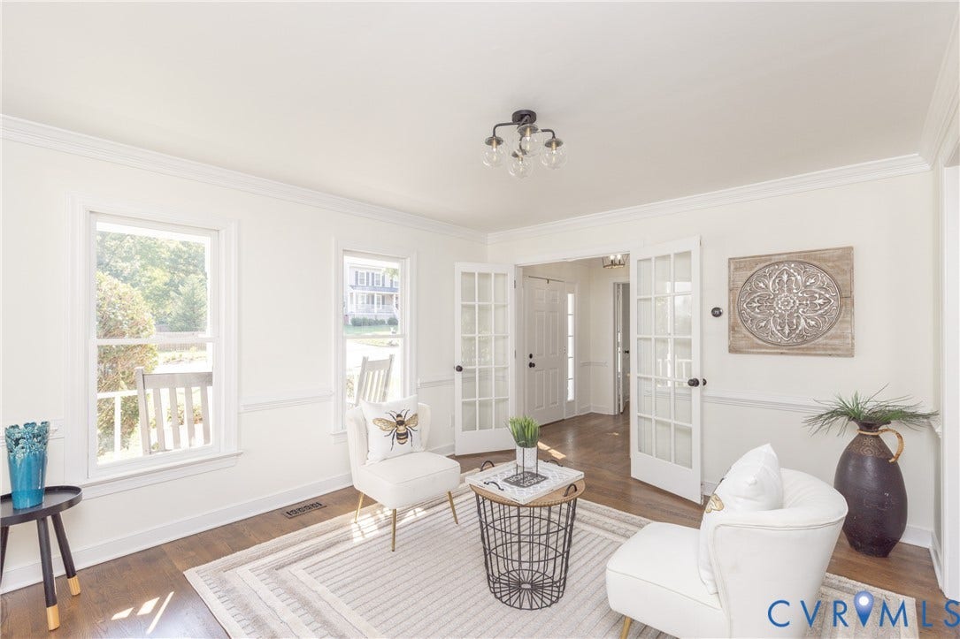 Hardwood flooring, crown molding, double French doors, large windows, and a semi-flush mount light fixture
