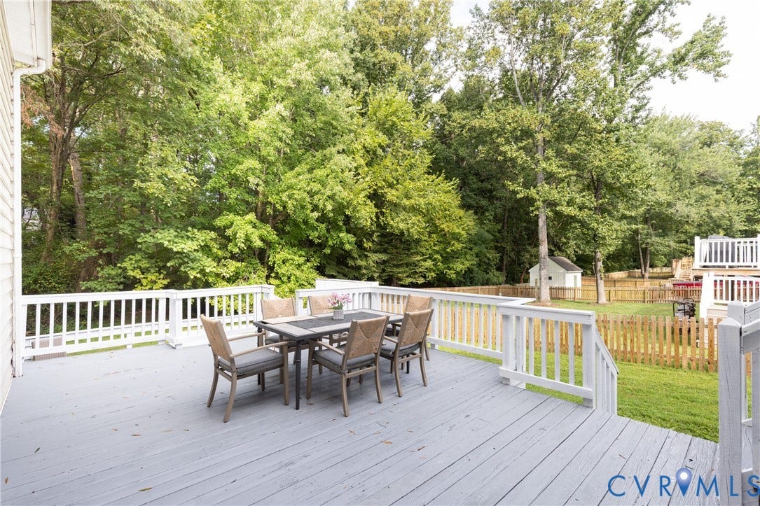 Expansive outdoor deck with white painted railings and a detached storage shed