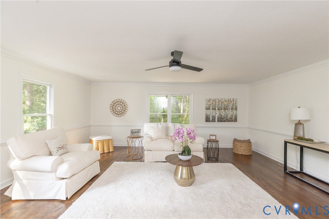 Hardwood flooring, crown molding, chair rail molding, ceiling fan, and multiple windows