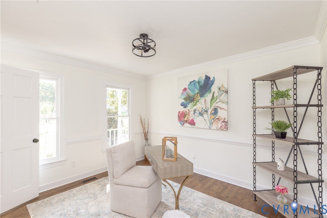 Recessed panel door, dual windows, wood-finish flooring, crown molding, and a flush mount light fixture