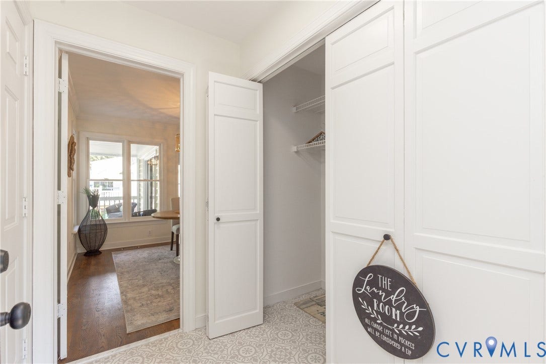 White paneled closet doors, patterned floor tile, and interior passage door with dark hardware